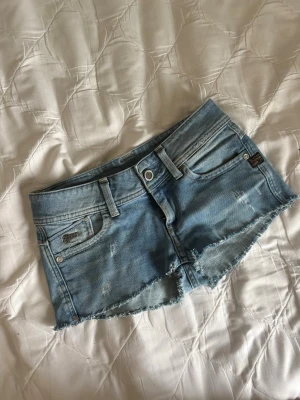 Ljusblå jeansshorts - Ett par ljusblå jeansshorts från g-star! Jätte snygga med fina detaljer! De är i storlek 27🩵