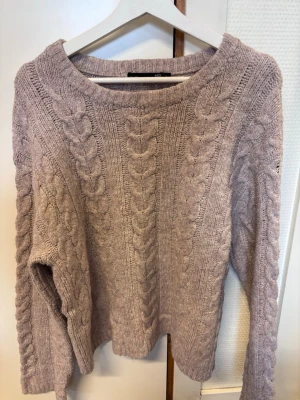 Beige kabelstickad tröja från 157 - Mysig beige kabelstickad tröja från 157 med bred rund halsringning och grova flätmönster framtill och på ärmarna. Perfekt för lager på lager och ger en avslappnad men ändå stilren look. Passar till jeans eller kjol. I stl L och sitter bra. Bara att höra av dig vid fler frågor eller fler bilder!💕