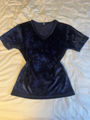 Mörkblå tshirt med v-ringning - Snygg mörkblå t-shirt med v-ringad hals. Det står ingen storlek men jag skulle säga S.