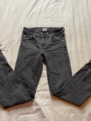 Svarta raka jeans från 157 - Säljer ett par svarta jeans från 157 med klassisk femficksmodell och utsvängda ben. Jeansen har normal midja och är tillverkade i ett mjukt denimtyg som sitter snyggt. Perfekta för dig som gillar en enkel och stilren look. Lite trasig på ena benet (se bild)