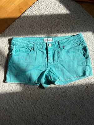 Turkosa shorts med fem fickor - Passar w25/26🥰🥰Snygga turkosa shorts med fem fickor och rå kant nertill. Klassisk knapp- och dragkedjestängning framtill. Perfekta för varma dagar och har en fräsch färg som sticker ut.