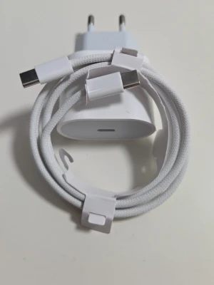 20 Watts Vit USB-C snabbladdare med kabel - Säljer en vit USB-C laddare med tillhörande flätad USB-C till USB-C kabel. Laddaren har en stilren och kompakt design i plast och kabeln är tålig med textilöverdrag. Perfekt för snabbladdning av mobiltelefoner och andra enheter. Passar iPhone och Android 