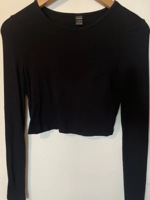 Svart långärmad crop top  - En svart långärmad crop top från shein med rund halsringning. Toppen är tight och har en kortare passform som slutar ovanför midjan🖤