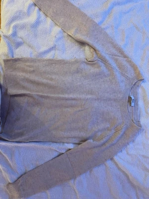Beige stickad tröja Rosemunde - Mysig beige stickad tröja från Rosemunde med rund halsringning och ribbade muddar vid ärmslut och nederkant. Enkel och stilren design som passar perfekt till lager på lager. Superskön och lätt att matcha med olika outfits.