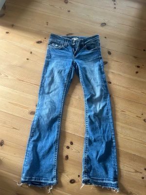 Blå jeans från Gina Young - Säljer ett par klassiska blå jeans från Gina Tricot i storlek 158. Jeansen är utsvängda och jag har sprättat upp dom längst ner. Perfekta till vardags för en avslappnad look.
