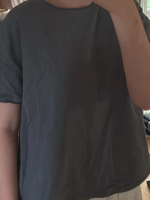 Mörkblå basic t-shirt - En enkel och stilren mörkblå t-shirt med rund hals och korta ärmar. T-shirten har en loose passform och är tillverkad i mjuk bomull, perfekt för en avslappnad look. Själv använd som mjukiskläder.