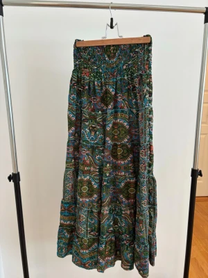 Grön långkjol  - Säljer en grön lång kjol i bohemisk stil med detaljer och mönster köpt i en butik på landet och går inte att hitta annan stans. Den har aldrig används.