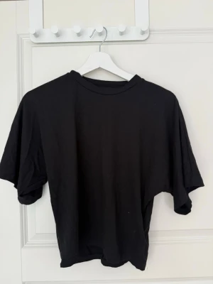 Svart t-shirt från 157 - En basic svart t-shirt från 157 med rund hals och korta ärmar. Tillverkad i mjuk bomull som känns skön mot huden. Perfekt att matcha med jeans eller shorts för en enkel och clean look. Man får med alla färgerna💕