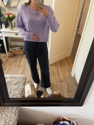 Ljuslila oversized stickad tröja - Säljer en ljuslila stickad tröja med v-ringning och avslappnad, oversized passform. Tröjan har långa ärmar och ribbade muddar vid ärmslut och nederkant. Perfekt för dig som gillar en chill och trendig stil.