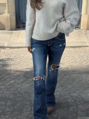 Blå jeans från Gina 14+💕 - Säljer ett par blå bootcut jeans med slitningar och hål på knäna och låret. Jeansen har lite slitage längst ner (sista bilden), men inge mycket💗 Bilderna är från förra ägaren då de var för korta för mig, men kan skicka mer bilder om så önskas🤗