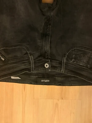 Svarta skinny jeans från Replay - Säljer ett par svarta skinny jeans från Replay med klassisk femficksdesign och tydliga sömmar. Jeansen har låg midja och smal passform som sitter tight hela vägen ner. Perfekta för dig som gillar en clean och stilren look. Size 31/32.köpta för 1549kr