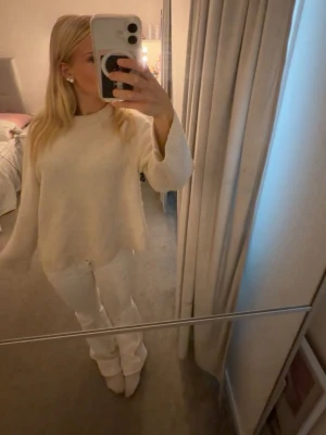 Krämvit oversized stickad tröja - Säljer en krämvit stickad tröja med avslappnad, oversized passform och långa ärmar. Tröjan har rund halsringning och är tillverkad i ett mjukt, tjockare material som passar perfekt för kyligare dagar.