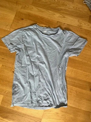 Ljusblå basic t-shirt - En enkel ljusblå t-shirt i mjuk bomull med rund hals och korta ärmar. Perfekt till jeans eller shorts för en avslappnad look. Klassisk passform och utan tryck eller detaljer.