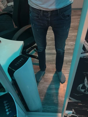  Replay jeans  - Säljer ett par mörkblå slim fit replay jeans med lätt slitna detaljer och klassisk femficksdesign. Jeansen har smal passform och normal midja, perfekta för en trendig och avslappnad look. Materialet är stretchigt för extra komfort. Längden mätt med måttband är 110cm.