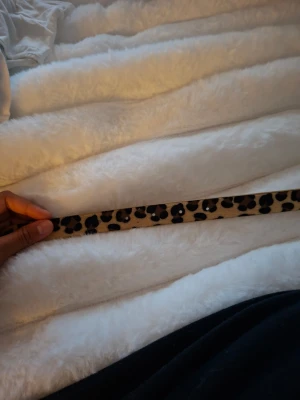 Leopardmönstrat bälte i beige och svart - Snyggt bälte med leopardmönster i beige och svart. Perfekt accessoar för att lyfta vilken outfit som helst. Bältet har flera hål för justerbar passform och är tillverkat i ett material som liknar skinn. Med fem håll .ge gärna prisförslag 