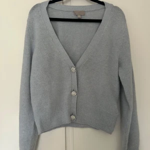Ljusgrå kofta från H&M - Säljer en ljusgrå kofta från H&M i storlek S med v-ringning och snygga knappar. Använd fåtal gånger! 💗
