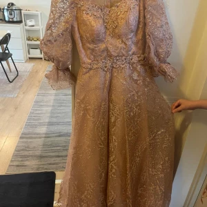 Rosa glittrig lång balklänning  - Elegant rosa långklänning med glittrande detaljer och spets. Klänningen har långa ärmar och en vacker v-ringad design. Perfekt för speciella tillfällen typ som balen, jag desgina den här själv i dubai för att jag ville ha en unik Princess aktig klänning till min bal. Älskar verkligen den här klänningen så sjukt mycket men har ingen mer användning till den därav säljer den. Ska lägga den på 500 men priset går defentivt att diskuteras. Den är stlk L-M men går alltid att sy in i Bodyn. 