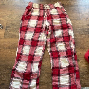 Röd- och vitrutiga byxor från Kappahl - Säljer ett par mysiga röd- och vitrutiga pjamasbyxor från Kappahl. Dom är väldigt sköna att sova i och sticks inte alls, använda ett fåtal gånger. 
