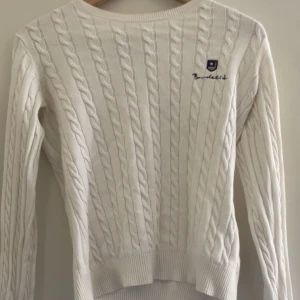 Vit stickad tröja - Fin tröja med bra kvalité, förutom att den har ett hål i armhålan.