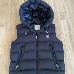 Moncler Väst - Svart moncler väst i storlek 3≈M, nfc funkar och jag kan garantera äkthet, använd fåtal gånger, modellen på bilden är 188cm och väger 75kg, kan gå ner i pris vid snabb affär