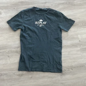 Svart t-shirt från Replay - Snygg svart t-shirt från Replay med tryck på bröstet. Perfekt för en avslappnad stil. Rund hals och korta ärmar gör den bekväm att bära.