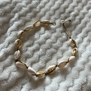 Halsband med snäckor och pärlor - Charmigt halsband med vita snäckor och justerbar knytning. 