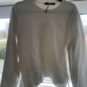 Vit tröja från Bikbok - Säljer en stilren vit tröja från Bikbok. Tröjan har en rund halsringning och långa ärmar, perfekt för en enkel och klassisk look. Passar bra till både jeans och kjol. Perfekt för kyligare dagar!