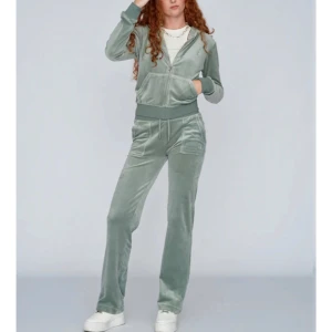 Grön velour hoodie - Snygg och bekväm grön velour hoodie med dragkedja och fickor framtill. Perfekt för en avslappnad stil. Matcha med byxor i samma material för en komplett look. Varan är få tal använd och jättefint skick!#juicycouture