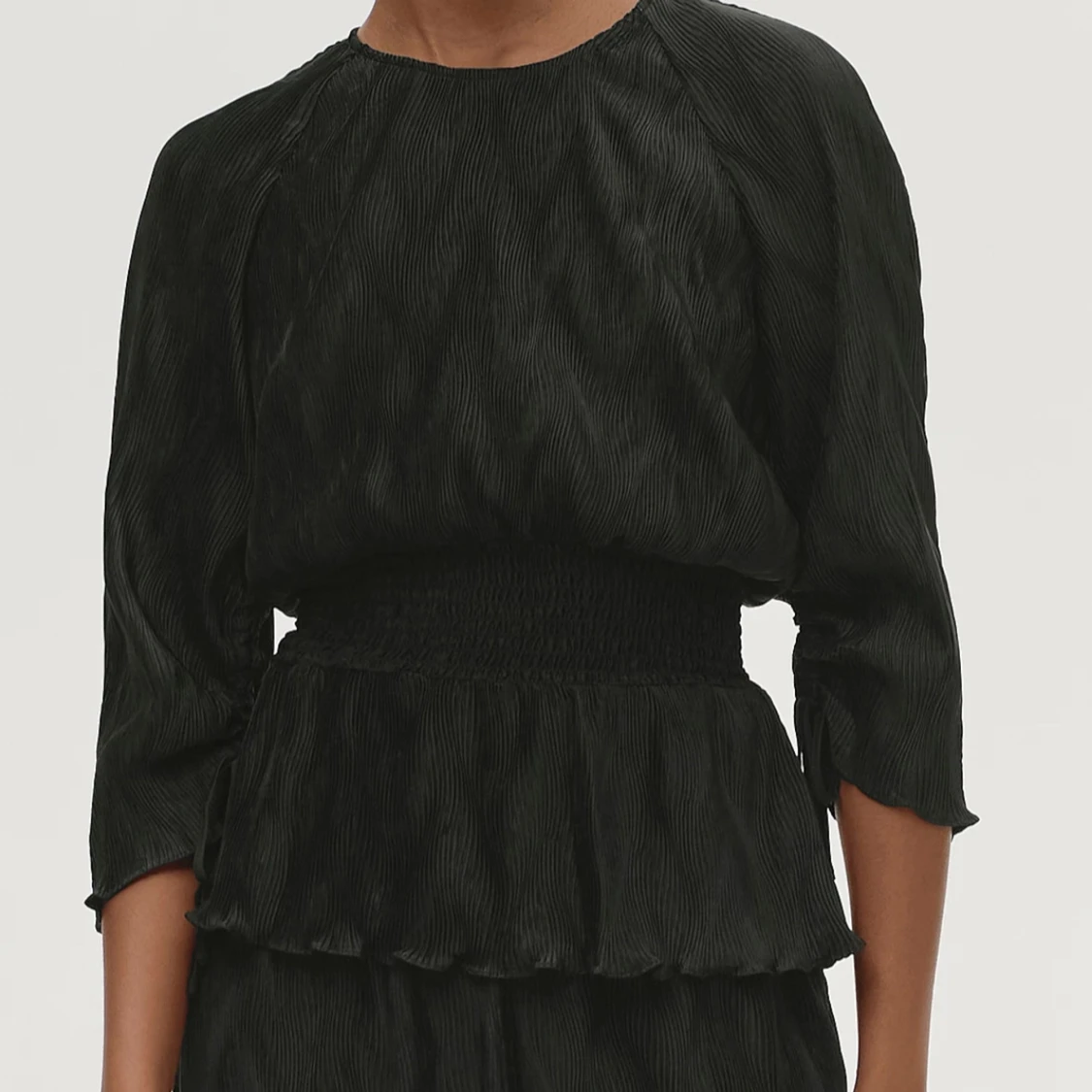 Svart blus med volangdetaljer