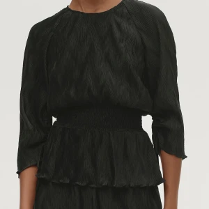 Svart blus med volangdetaljer - Snygg svart blus med volangdetaljer i midjan och trekvartsärmar. Perfekt för en stilren look.💕💕Nypris 800 kr