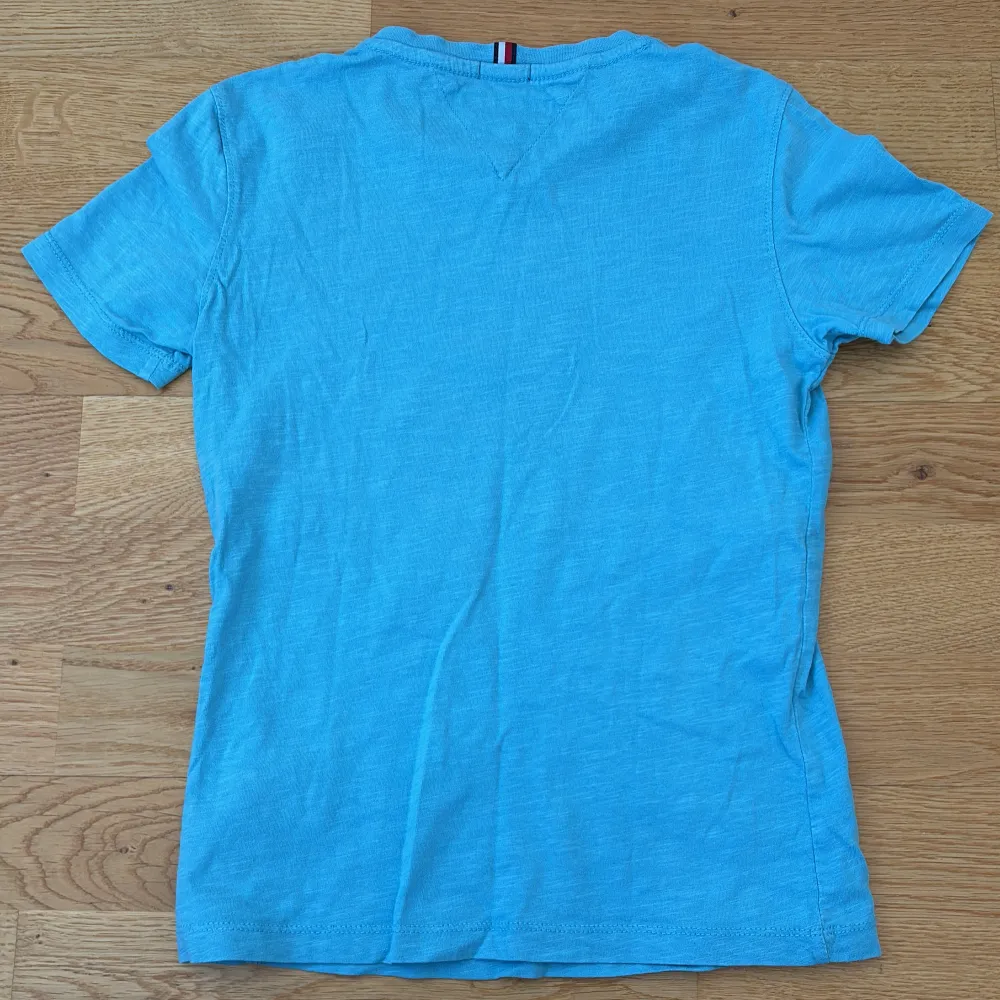 Snygg blå t-shirt från Tommy Hilfiger i ekologisk bomull. Den har korta ärmar och ett stort tryck med logotypen på framsidan. Perfekt för en avslappnad stil.. T-paidat.
