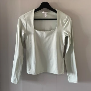 Ljusgrön långärmad topp från H&M - Säljer en stilren ljusgrön långärmad topp från H&M. Toppen har en fyrkantig urringning och är perfekt för en minimalistisk look. Materialet är mjukt och bekvämt, vilket gör den idealisk för både vardag och speciella tillfällen. Den har även dubbeltyg. Säljer då den aldrig kommit till användning. Skriv vid funderingar eller fler bilder 💞