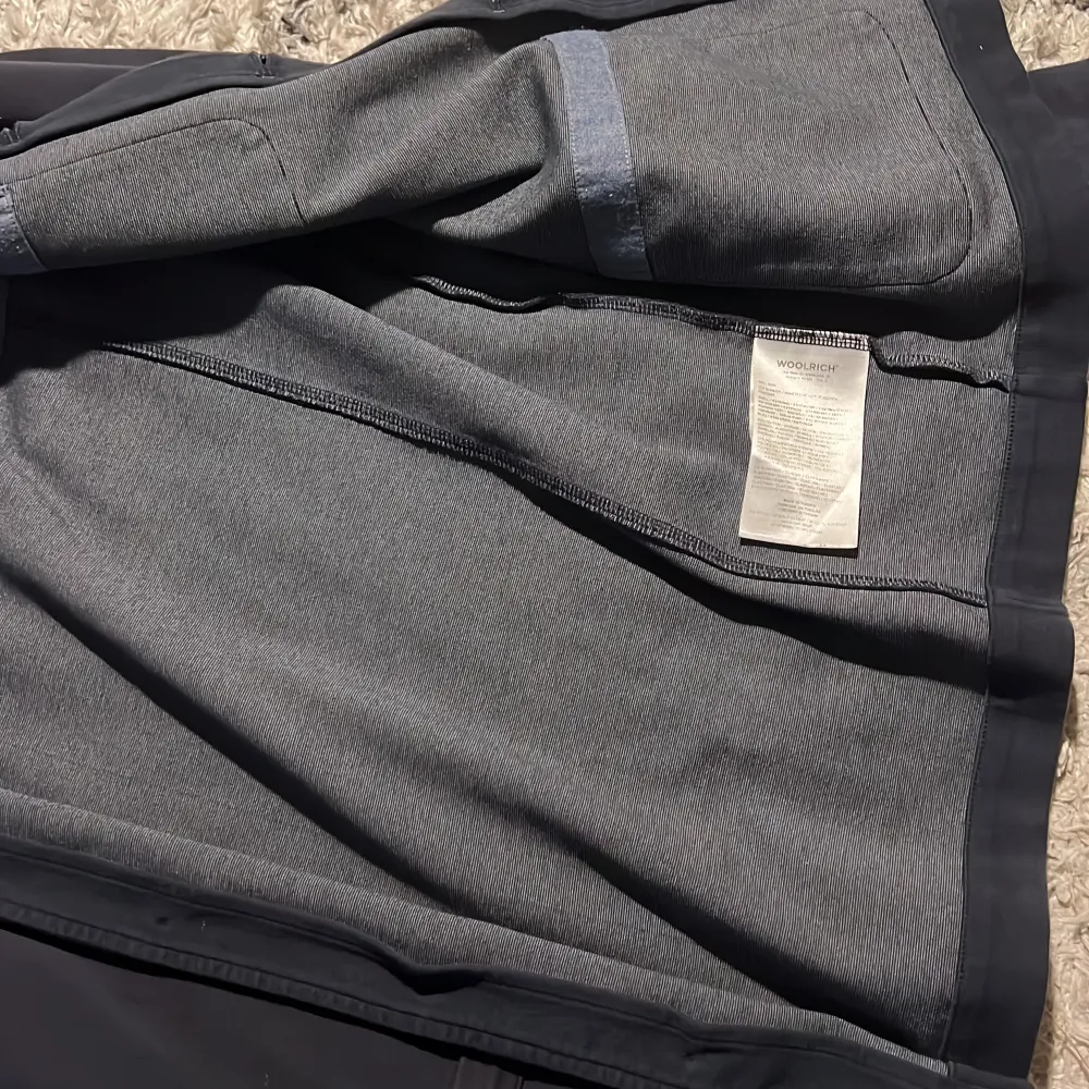 Säljer en stilren mörkblå overshirt från Woolrich. Jackan har långa ärmar och knappar framtill. Det är ull material och har en perfekt stilren look. Passar perfekt nu till sommarn kombinerad med en skjorta elr vit t-shirt. Den har används med noggrannhet och är i mycket bra sick. Storlek S och passar folk runt 175-180. Skriv vid funderingar!. Takit.