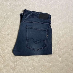 Mörkblå Replay Jeans - Mörkblå Replay anbass jeans i strl 32. Jeansen har en normal passform. Mycket gott skick.