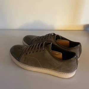 Lanvin cap toe uk 9 - Snygga grå sneakers med en glansig tå och snörning. Skorna är 9/10 skick och har inga defekter.skorna sitter som en 43-44 då lanvin är större i storlekarna.Om ni har frågor är det bara att fråga.Pris ej hugget i sten🪨tvättar skorna såklart innan jag skickar skorna😁kan vara intressant med byten.