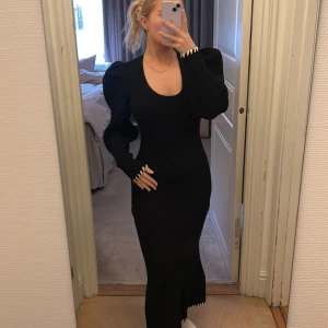 Svart ribbad klänning från ADOORE - Snygg svart ribbad klänning från ADOORE med lång ärm och figurnära passform. Klänningen har en rund halsringning och stilrena detaljer vid ärmsluten. Perfekt för en elegant look. Helt oanvänd med etikett kvar. Nypris 1 595 kr 