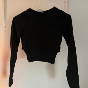 Svart croppad långärmad topp - Svart långärmad topp med cut outes på sidorna. Från asos💕