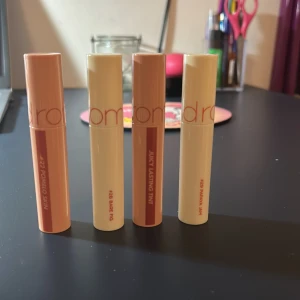rom&nd Juicy Lasting Tint  - Fyra olika nyanser av Juicy Lasting Tint läpprodukter. Varje tub har en applikator och kommer i färger som sträcker sig från ljus beige till djupare brun. Perfekt för att ge läpparna en glansig och färgstark look. 80kr/styck