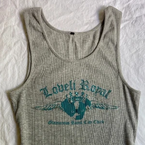 Grå ribbad linnetopp med tryck - Grå ribbad linne med ett tryck i och glittrande stenar på framsidan. Skriv för fler bilder eller frågor!😊