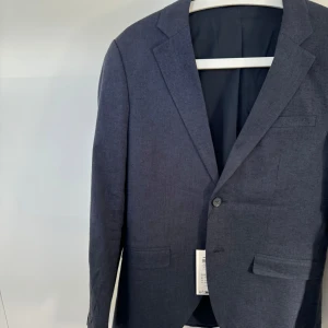 Mörkblå linnekavaj  - Mörkblå linnekavaj från Jack & Jones. Aldrig använd, kvitto finns kvar på. Köpt för 1099kr