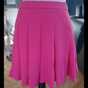 Rosa kjol från Shein - Säljer en söt rosa kjol från Shein med dragkedja i sidan. Perfekt för att liva upp garderoben med lite färg! Aldrig använd!