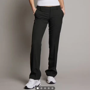 Svarta kostymbyxor - Säljer dessa lågmidjade, bootcut kostymbyxor i storlek 34, längd regular, modell ”Vera” från Bikbok då de är lite för stora för mig. Längden passar perfekt på mig som är 1,68 cm.