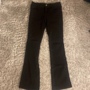 Svarta jeans från ONLY - Snygga svarta jeans från ONLY med klassisk design och knappstängning. Perfekta för en stilren look.