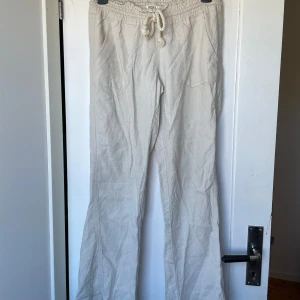 Roxy linnebyxor  - Beigea lowwaist linnebyxor från Roxy i strl XS. Använda fåtal gånger förra sommaren så i jättebra skick! Sytt upp själv så passar upp till ca 165 cm. Finns en liiiten fläck under högra bakfickan men syns knappt (se bild).