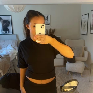 Svart topp med öppen rygg  - Säljer en svart topp med knyt i ryggen. Toppen har korta ärmar och en tight passform, perfekt till sommarn