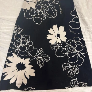 Blommig kjol - Fin blommig kjol med högre midja. Köpt secondhand men säljs vidare då den ej används. I gott skick förutom små upprivna texilfibrer (se sista bilden).