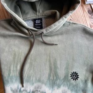 Tie-dye hoodie från Sweet Sktbs XS - Säljer en oversized hoodie från Sweet Sktbs i tie-dye mönster med gröna, beige och blå toner. 