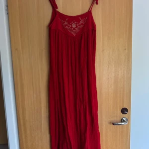 Röd långklänning - Röd långklänning med broderade detaljer upptill och en luftig passform💃