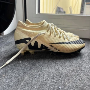 Nike Zoom Vapor 15 pro fotbollskor  - Snygga beige Nike Air Zoom fotbollsskor som är max använda tre gånger. Säljer för de är för små för mig. Möjligt att de är någon enstaka gräsfläck för jag tränar på gräsplan, men annars är de så gott som nya!!  Nypris: 1350kr