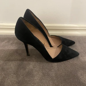 Svarta mockapumps från Zara - Stilrena svarta pumps från Zara i mjuk mocka med spetsig tå och smal klack. Snygg och klassisk modell som ger en elegant look. 